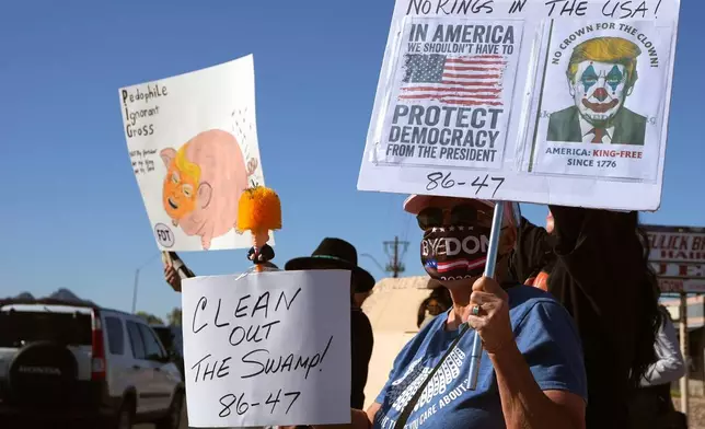 Protesters gather prior to a Turning Point USA event where President Donald Trump is scheduled to speak Friday, April 17, 2026, in Phoenix. (AP Photo/Ross D. Franklin)