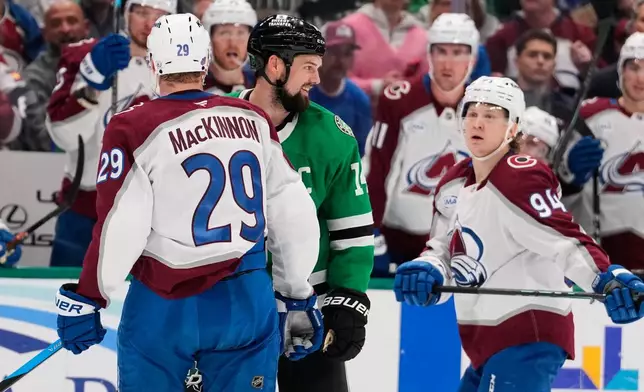 Colorado Avalanche's Nathan MacKinnon (29) and Dallas Stars' Jamie Benn (14) exchange words as Joel Kiviranta (94) looks on in the second period of an NHL hockey game Saturday, April 4, 2026, in Dallas. (AP Photo/Tony Gutierrez)
