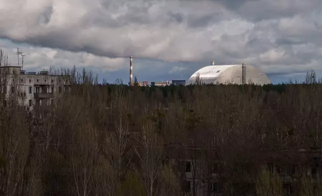 The Chernobyl nuclear power plant and the New Safe Confinement structure that was built to shield the damaged Reactor No. 4, is seen on Monday, April 6, 2026, from the abandoned town of Pripyat, Ukraine, where the workers at the plant once lived. (AP Photo/Evgeniy Maloletka)