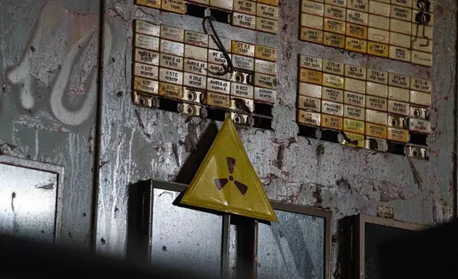 A radiation warning sign is seen on April 6, 2026, in the control room for Reactor No. 4 that exploded and burned in 1986 at the Chernobyl nuclear power plant in Ukraine. (AP Photo/Evgeniy Maloletka)