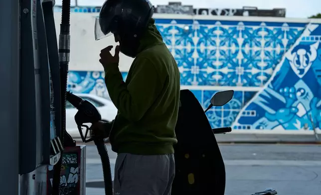Neer Malik fills up just one gallon of gasoline to ride approximately 100 miles on his motorcycle at a gas station in Los Angeles on Friday, April 17, 2026. (AP Photo/Damian Dovarganes)