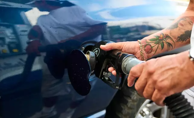 A motorist fills up his truck for over a $100 at a gas station in Los Angeles on Friday, April 17, 2026. (AP Photo/Damian Dovarganes)