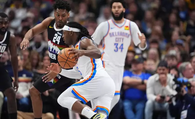 Oklahoma City Thunder guard Luguentz Dort, front, drives past Denver Nuggets guard Jalen Pickett (24) in the first half of an NBA basketball game Friday, April 10, 2026, in Denver. (AP Photo/David Zalubowski)