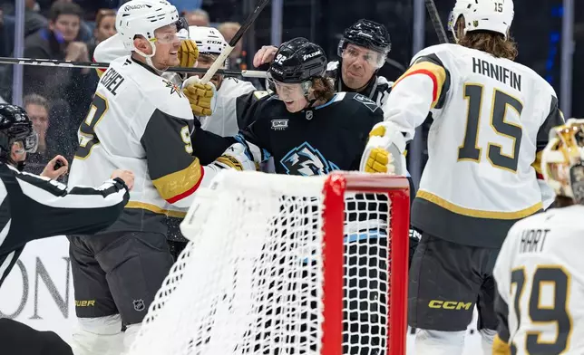 Utah Mammoth center Logan Cooley (92) fights with Vegas Golden Knights center Jack Eichel (9) during the first period of Game 3 of the first round in an NHL hockey Stanley Cup playoff series, Friday, April 24, 2026, in Salt Lake City. (AP Photo/Melissa Majchrzak)