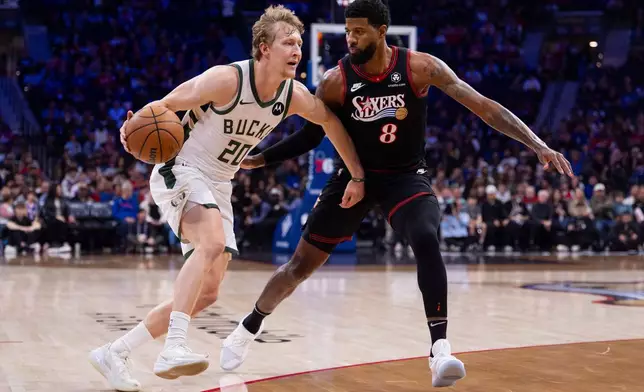 Milwaukee Bucks shooting guard AJ Green, left, drives to the basket against Philadelphia 76ers small forward Paul George, right, during the first half of an NBA basketball game, Sunday, April 12, 2026, in Philadelphia. (AP Photo/Chris Szagola)