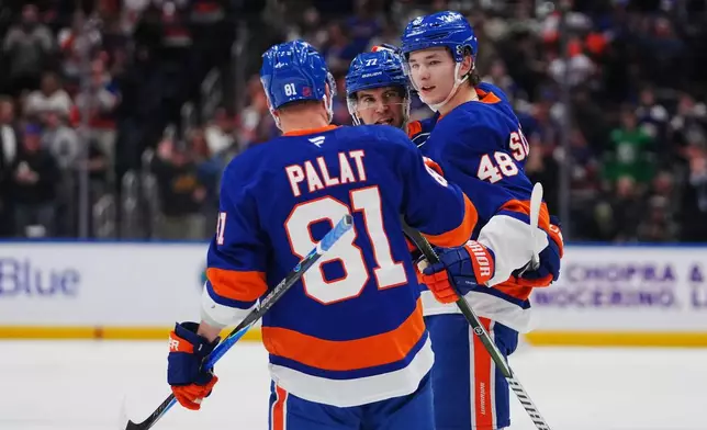 New York Islanders' Matthew Schaefer (48) celebrates with teammates Tony DeAngelo (77) andn Ondrej Palat (81) after scoring a goal during the second period of an NHL hockey game against the Toronto Maple Leafs Thursday, April 9, 2026, in Elmont, N.Y. (AP Photo/Frank Franklin II)