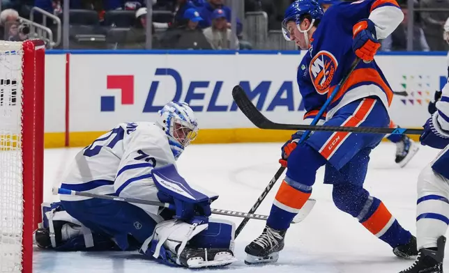 Toronto Maple Leafs goaltender Artur Akhtyamov, left, protects the net from New York Islanders' Calum Ritchie during the second period of an NHL hockey game Thursday, April 9, 2026, in Elmont, N.Y. (AP Photo/Frank Franklin II)