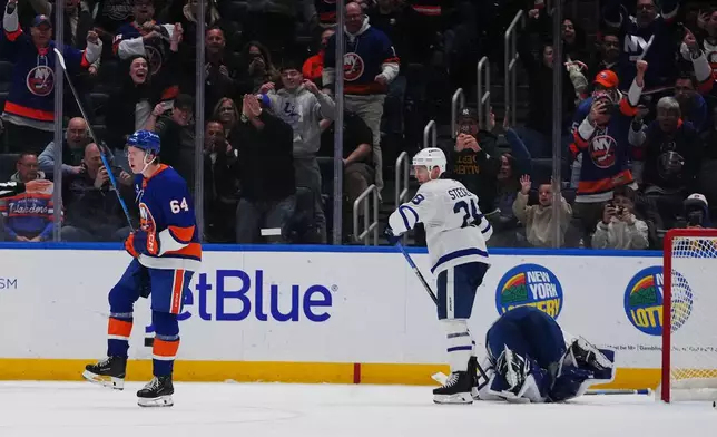 New York Islanders' Calum Ritchie (64) celebrates after scoring a goal as Toronto Maple Leafs' Troy Stecher (28) and Toronto Maple Leafs goaltender Artur Akhtyamov react during the third period of an NHL hockey game Thursday, April 9, 2026, in Elmont, N.Y. (AP Photo/Frank Franklin II)