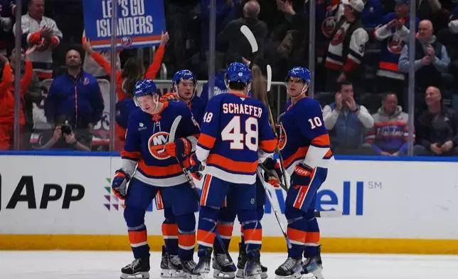 New York Islanders' Calum Ritchie, left, celebrates with teammates after scoring a goal during the third period of an NHL hockey game against the Toronto Maple Leafs Thursday, April 9, 2026, in Elmont, N.Y. (AP Photo/Frank Franklin II)