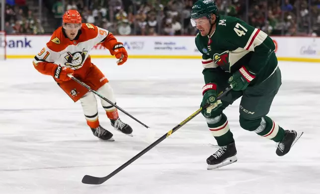 Minnesota Wild's Michael McCarron (47) controls the puck ahead of Anaheim Ducks' Leo Carlsson (91) during the third period of an NHL hockey game Tuesday, April 14, 2026, in St. Paul, Minn. (AP Photo/Lily Dozier)