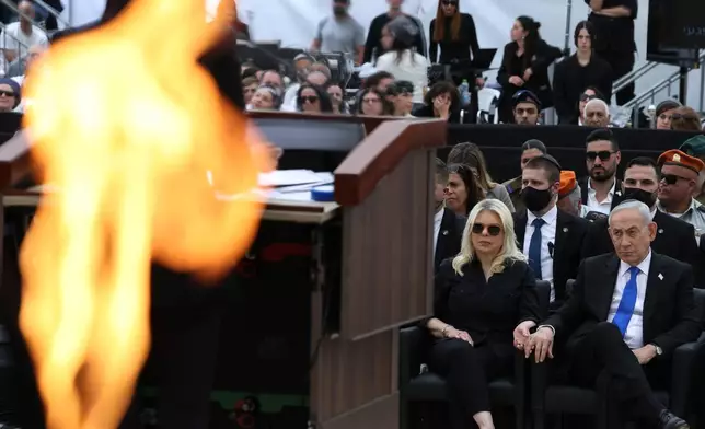 Israel's Prime Minister Benjamin Netanyahu, right, holds the hand of his wife Sara during a ceremony commemorating Israel's Remembrance Day for fallen soldiers, or Yom HaZikaron, at the Military Cemetery on Mount Herzl in Jerusalem, Tuesday April 21, 2026. (Ilia Yefimovich/Pool Photo via AP)