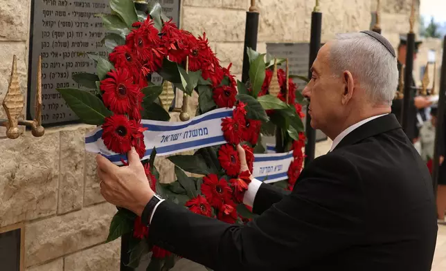 Israel's Prime Minister Benjamin Netanyahu places a wreath during a ceremony commemorating Israel's Remembrance Day for fallen soldiers, or Yom HaZikaron, at the Military Cemetery on Mount Herzl in Jerusalem, Tuesday April 21, 2026. (Ilia Yefimovich/Pool Photo via AP)