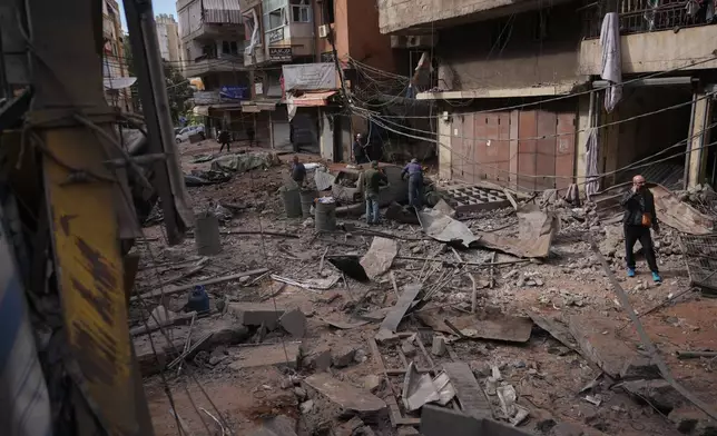 People inspect debris and damaged vehicles at the site of an Israeli airstrike in Dahiyeh, Beirut's southern suburbs, Lebanon, Thursday, April 9, 2026. (AP Photo/Hassan Ammar)