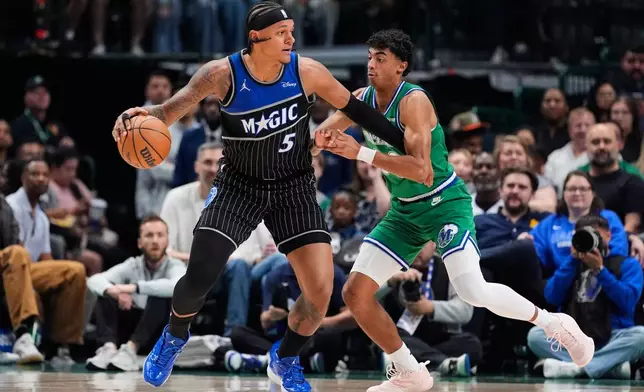 Orlando Magic forward Paolo Banchero (5) works to the basket against Dallas Mavericks' Max Christie, right, in the first half of an NBA basketball game Friday, April 3, 2026, in Dallas. (AP Photo/Tony Gutierrez)