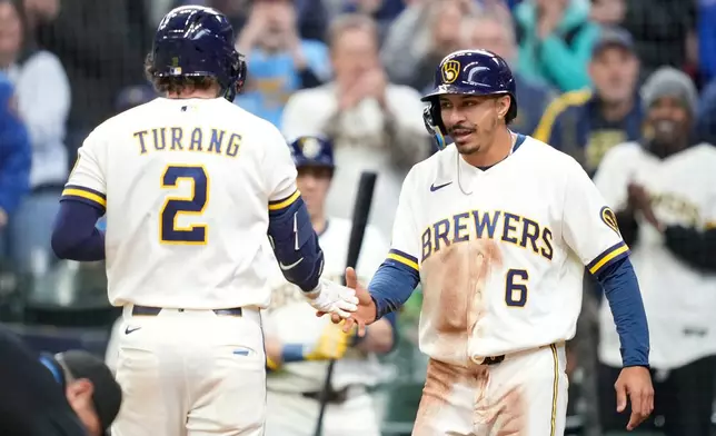 Milwaukee Brewers' David Hamilton (6) high-fives Brice Turang (2) following Turang's two-run home run during the third inning of a baseball game against the Tampa Bay Rays, Wednesday, April 1, 2026, in Milwaukee. (AP Photo/Kayla Wolf)