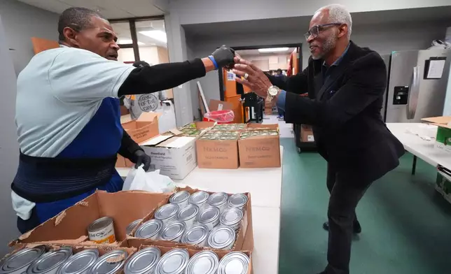 Richard Miles, right, founder and CEO of Miles of Freedom, a Dallas-based group that provides help for individuals after they have been released from prison, whether they are on parole or are exonerees, greets his organization's soup kitchen volunteer Frederick Briscoe on Tuesday, April 21, 2026 in Dallas. (AP Photo/Julio Cortez)