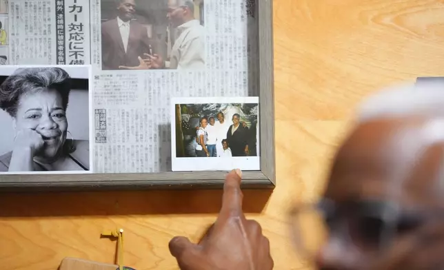 Richard Miles, founder and CEO of Miles of Freedom, a Dallas-based group that provides help for individuals after they have been released from prison, whether they are on parole or are exonerees, points to a photograph of his family members visiting in prison during an interview with The Associated Press, Tuesday, April 21, 2026 in Dallas. (AP Photo/Julio Cortez)
