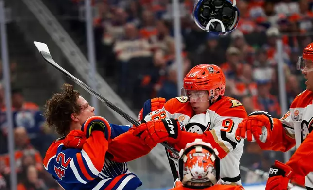 Anaheim Ducks' Pavel Mintyukov (98) battles against Edmonton Oilers' Kasperi Kapanen (42) during second period NHL playoff action in Edmonton on Wednesday, April 22, 2026. (Codie McLachlan/The Canadian Press via AP)