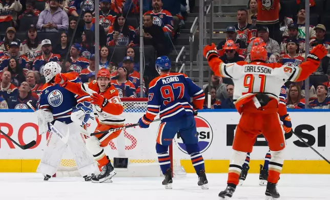 Anaheim Ducks' Cutter Gauthier (61) and Leo Carlsson (91) celebrate a goal against Edmonton Oilers goaltender Connor Ingram (39) during the second period of an NHL hockey playoff game in Edmonton, Alberta, on Wednesday, April 22, 2026. (Codie McLachlan/The Canadian Press via AP)