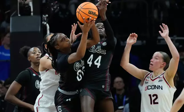 South Carolina guard Ta'Niya Latson (00) and South Carolina guard Agot Makeer (44) go for a rebound against UConn during the first half of a woman's NCAA college basketball tournament semifinal game at the Final Four, Friday, April 3, 2026, in Phoenix. (AP Photo/Ross D. Franklin)