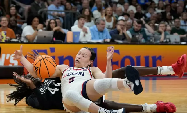South Carolina guard Agot Makeer (44) and UConn guard Kayleigh Heckel (9) scramble for the ball during the second half of a woman's NCAA college basketball tournament semifinal game at the Final Four, Friday, April 3, 2026, in Phoenix. (AP Photo/Ross D. Franklin)