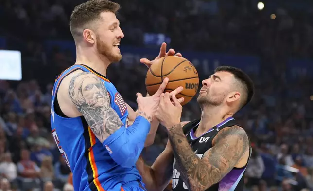 Utah Jazz guard John Konchar, right, knocks the ball away from Oklahoma City Thunder center Isaiah Hartenstein, left, during the first half of an NBA basketball game Sunday, April 5, 2026, in Oklahoma City. (AP Photo/Nate Billings)