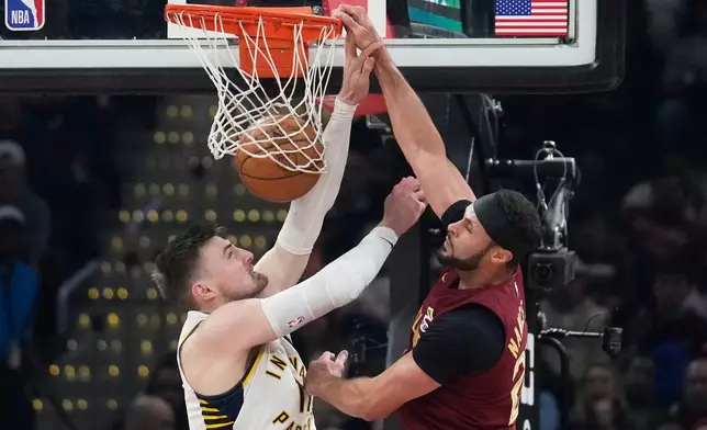 Cleveland Cavaliers forward Larry Nance Jr. (22) dunks ober Indiana Pacers center Micah Potter, left, in the first half of an NBA basketball game in Cleveland, Sunday, April 5, 2026. (AP Photo/Sue Ogrocki)