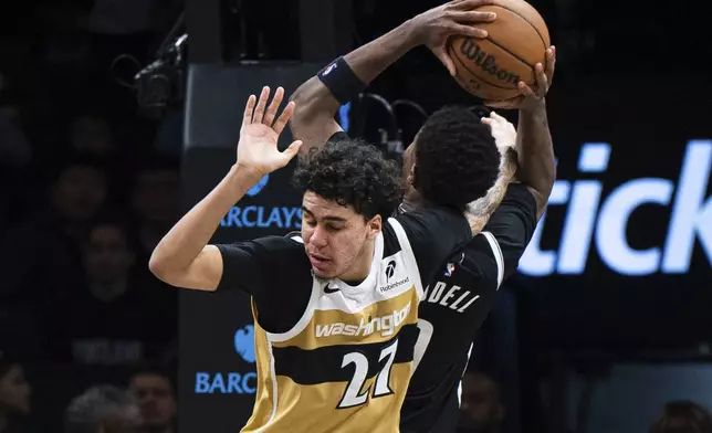 Washington Wizards guard Will Riley (27) gets his arm stuck with Brooklyn Nets forward E.J. Liddell (9) during the second half of an NBA basketball game, Sunday, April 5, 2026, in New York. (AP Photo/Angelina Katsanis)