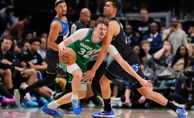 Dallas Mavericks forward Cooper Flagg (32) works to the basket against Orlando Magic forward Tristan da Silva, right, in the second half of an NBA basketball game Friday, April 3, 2026, in Dallas. (AP Photo/Tony Gutierrez)