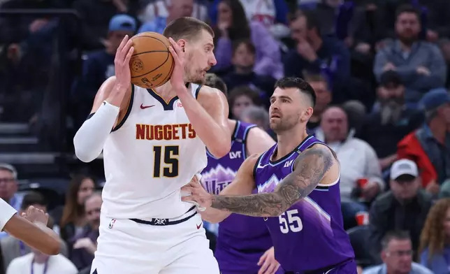Denver Nuggets center Nikola Jokic (15) looks for a play against Utah Jazz guard John Konchar (55) during the first half of an NBA basketball game, Wednesday, April 1, 2026, in Salt Lake City. (AP Photo/Rob Gray)