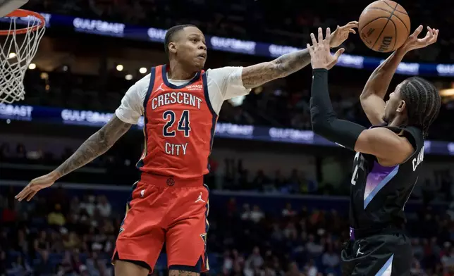 New Orleans Pelicans guard Jordan Hawkins (24) blocks the shot of Utah Jazz guard Kennedy Chandler (0) during the first half of an NBA basketball game in New Orleans, Tuesday, April 7, 2026. (AP Photo/Matthew Hinton)