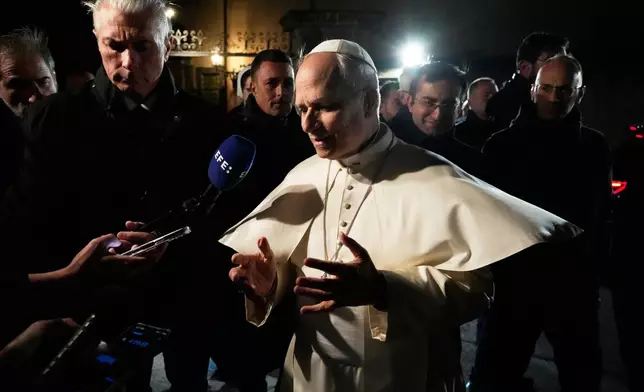 Pope Leo XIV talks to journalists as he leaves his residence in Castel Gandolfo, on the outskirts of Rome, to return to the Vatican, Tuesday, March 31, 2026. (AP Photo/Gregorio Borgia)