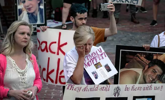 FILE - Protesters who have lost love ones to the opioid crisis protest outside a courthouse in Boston, Aug. 2, 2019, where a judge heard arguments in a lawsuit against Purdue Pharma. (AP Photo/Charles Krupa, File)