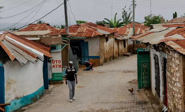 A man walks along an alley in Owino Uhuru village, an informal settlement in Mikindani, Mombasa County, Kenya, on April 10, 2026. (AP Photo/Kelvin Rading)
