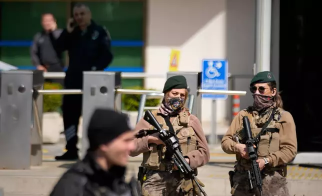 Turkish police and army secure the area after a gunmen attack at a building housing the Israeli Consulate in Istanbul, Turkey, Tuesday, April 7, 2026. (AP Photo/Khalil Hamra)