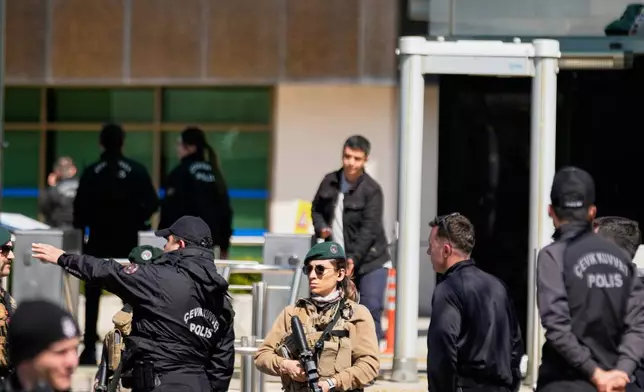 Turkish police and army secure the area after a gunmen attack at a building housing the Israeli Consulate in Istanbul, Turkey, Tuesday, April 7, 2026. (AP Photo/Khalil Hamra)