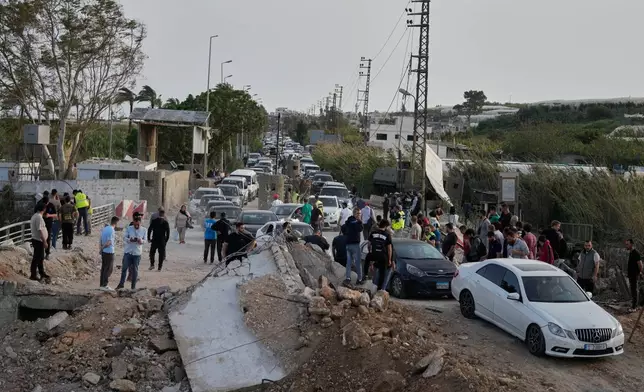 Displaced people returning to their villages following a ceasefire between Hezbollah and Israel, cross the destroyed Qasmiyeh bridge near Tyre city, south Lebanon, Friday, April 17, 2026. (AP Photo/Mohammed Zaatari)