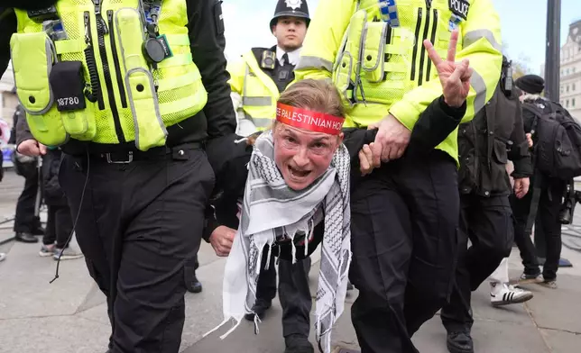 Police remove a protester at a demonstration against the ban on Palestine Action, in Trafalgar Square, central London, Saturday April 11, 2026. (Lucy North/PA via AP)