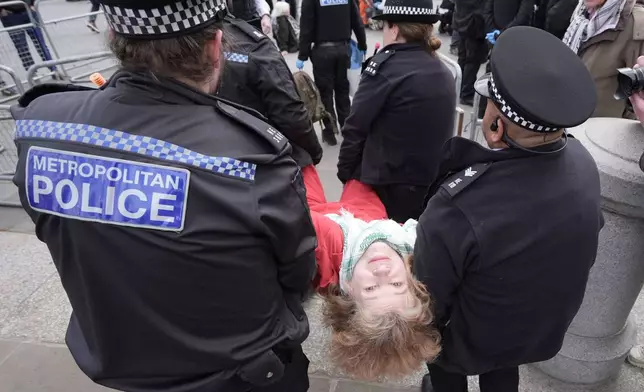 Police remove a protester at a demonstration against the ban on Palestine Action, in Trafalgar Square, central London, Saturday April 11, 2026. (Stefan Rousseau/PA via AP)