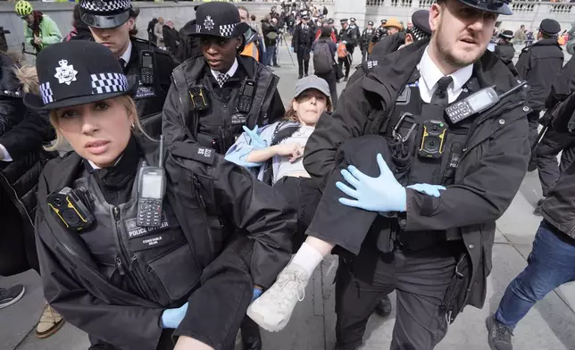 Police remove a protester at a demonstration against the ban on Palestine Action, in Trafalgar Square, central London, Saturday April 11, 2026. (Stefan Rousseau/PA via AP)