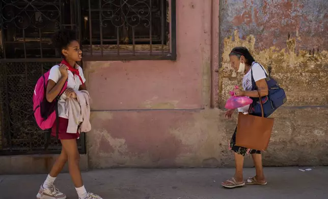 Mercedes Lopez Rey, 83, carries a meal from a church-sponsored program to a homebound friend, in Old Havana, Cuba, Wednesday, Feb. 19, 2025. (AP Photo/Ramon Espinosa)