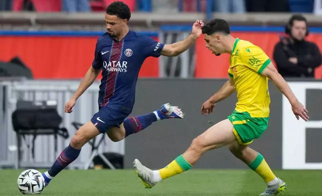 PSG's Warren Zaire-Emery, left, challenge with Nantes' Matthis Abline during the French League One soccer match between Paris Saint-Germain and Nantes in Paris, France, Wednesday, April 22, 2026. (AP Photo/Michel Euler)