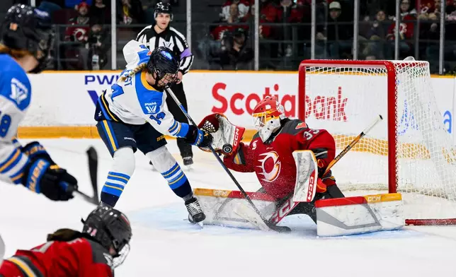 Ottawa Charge's goaltender Gwyneth Philips (33) tries to make a save while being pressured by Toronto Sceptres' Renata Fast (14) during the second period of a PWHL hockey game in Ottawa, Ontario, Saturday, April 25, 2026. (Spencer Colby/The Canadian Press via AP)