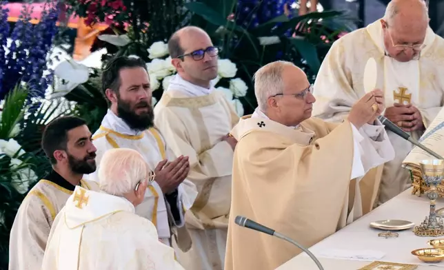 Pope Leo XIV, with Cardinal Kevin Joseph Farrell, chamberlain of the Holy Roman Church, right, and Cardinal Giovanni Battista Re, dean of the College of Cardinals, left, presides over Easter Mass in St. Peter's Square at the Vatican, Sunday, April 5, 2026. (AP Photo/Alessandra Tarantino)