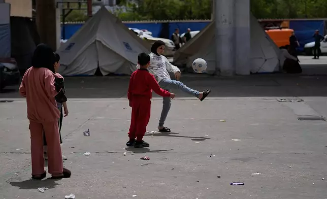 Displaced children play with a ball at a school backyard that turned into a shelter for people who fled the Israeli airstrikes on their villages, in the southern port city of Sidon, Lebanon, Tuesday, April 14, 2026. (AP Photo/Mohammed Zaatari)