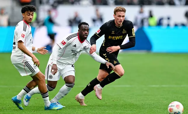 Cologne's Sebastian Sebulonsen, right, and Frankfurt's Nathaniel Brown, left, and Arnaud Kalimuendo battle for the ball during the German Bundesliga soccer match between Eintracht Frankfurt and 1. FC Cologne in Frankfurt, Germany, Sunday, April 5, 2026. (Uwe Anspach/dpa via AP)