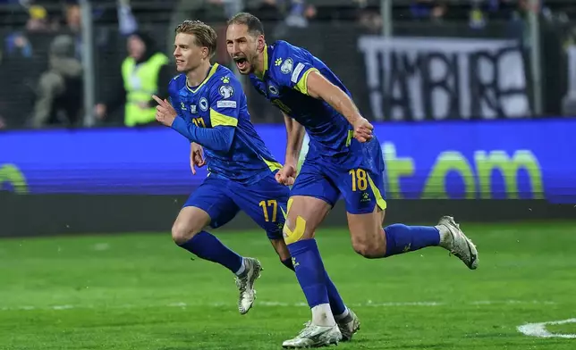 Bosnia's Nikola Katic, right, and Bosnia's Dzenis Burnic celebrate after winning a penalty shootout during the World Cup qualifying playoff final soccer match between Bosnia and Italy in Zenica, Bosnia, Tuesday, March 31, 2026. (AP Photo/Armin Durgut)