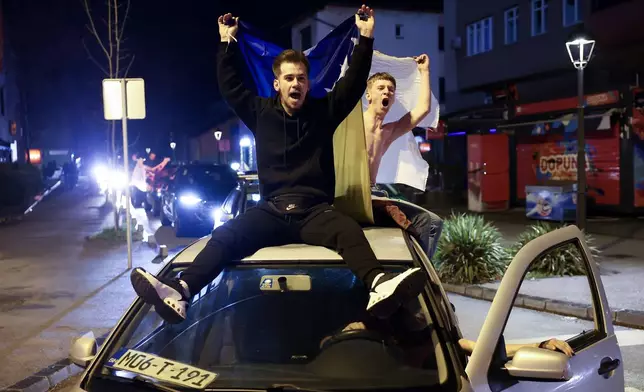 Bosnian fans wave flags as they celebrate after the Bosnian national team qualified for the World Cup by winning a penalty shootout against Italy, in Zenica, Bosnia, Wednesday, April 1, 2026. (AP Photo/Armin Durgut)