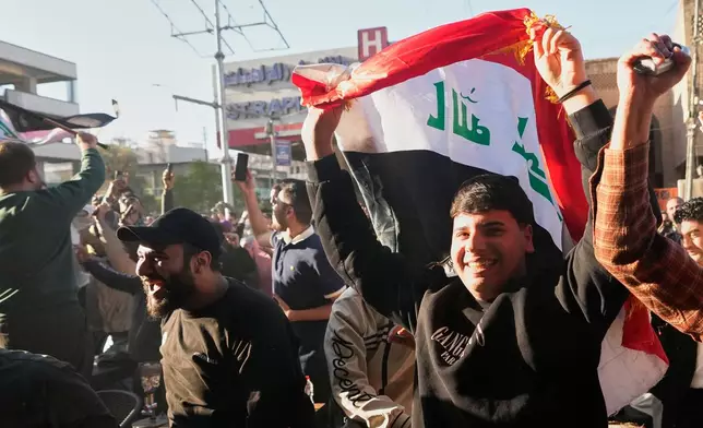 Iraqi fans cheer in Baghdad, Iraq, Wednesday, April 1, 2026, after their country's second goal against Bolivia in a World Cup 2026 playoff final. (AP Photo/ Hadi Mizban)