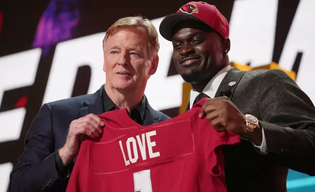 Notre Dame running back Jeremiyah Love, right, poses with NFL Commissioner Roger Goodell after being chosen by the Arizona Cardinals with the third overall pick during the first round of the NFL football draft, Thursday, April 23, 2026, in Pittsburgh. (AP Photo/Gene J. Puskar)
